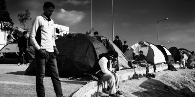 black and whire image of people standing in front of small tents